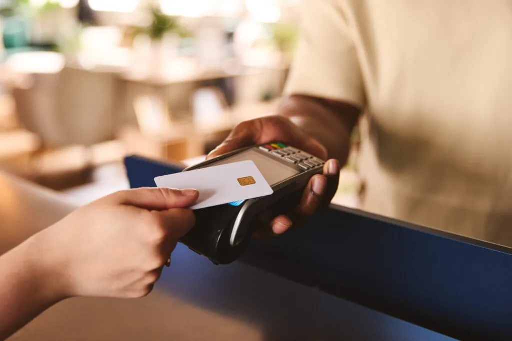 a person tapping their credit card to a credit card machine