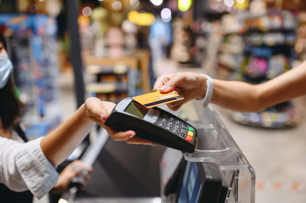 a woman is paying her credit card at the cash register